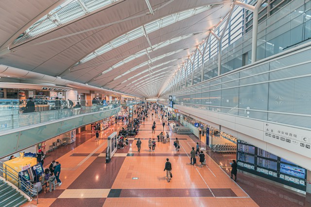 The concourse of an airport terminal with travelers walking through